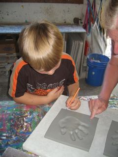 Stephan signing his handprint tile